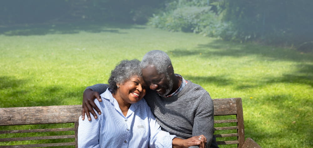 elderly retired african american couple bench assisted living facility lawn bench