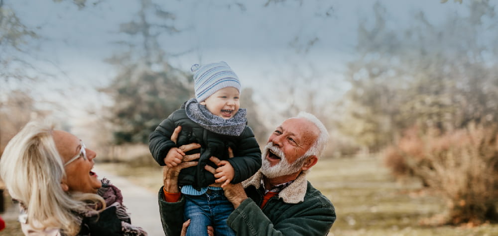 elder retired white grandparents grandchild outside at long-term nursing home facility