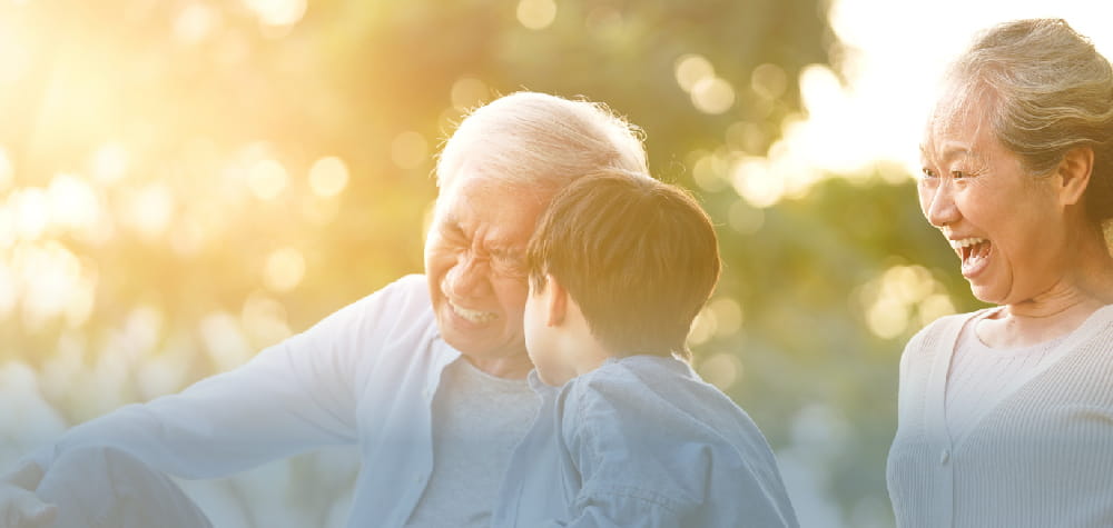 Elder retired Asian grandparents with grandchild outside assisted living facility